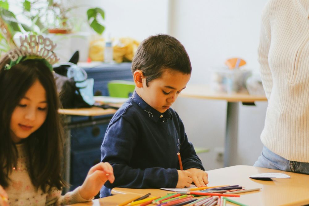 Children coloring at a table in a classroom